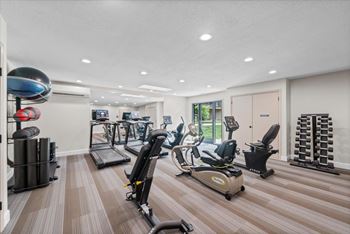 A gym with a variety of equipment including treadmills, stationary bikes, and weight machines.
